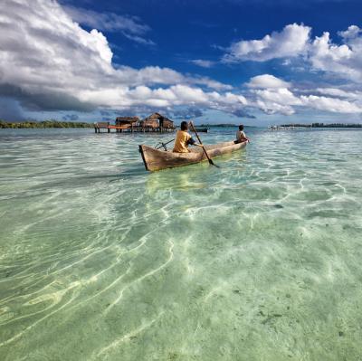 Row a dugout canoe in Indonesia